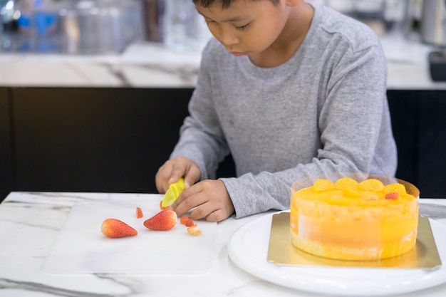 Heureux petit garçon fait un gâteau