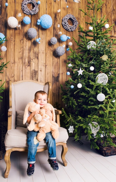 Heureux petit garçon jouant près de l'arbre de Noël
