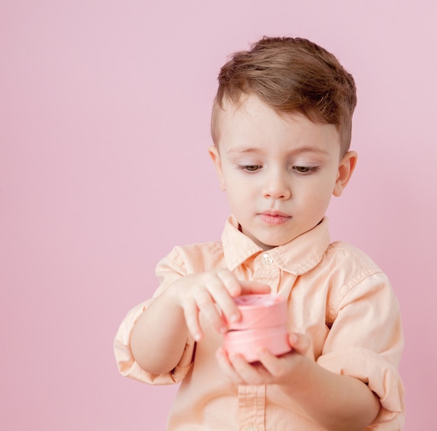 Heureux petit garçon ouvrant un cadeau isolé