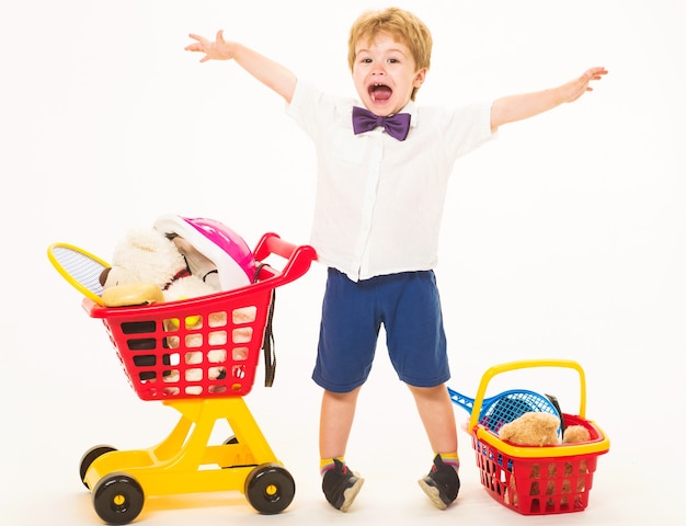 Heureux petit garçon avec panier et panier. L'enfant joue dans la boutique. Shopping, remise, concept de vente.