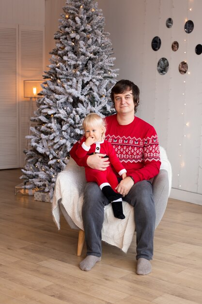 Heureux petit garçon et père dans une salle décorée de fête pour Noël