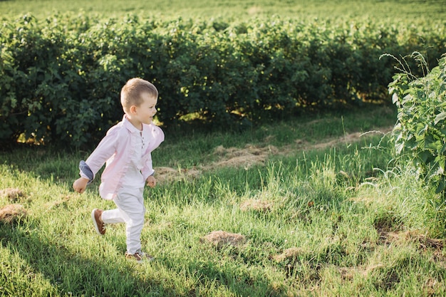 Heureux petit garçon qui court sur le terrain