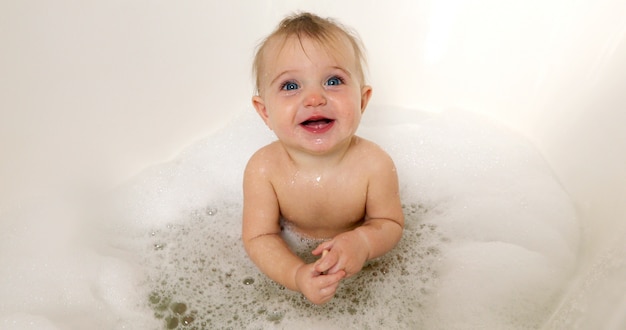 Heureux petit garçon en riant dans la baignoire