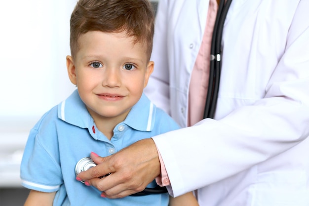Heureux petit garçon s'amusant pendant qu'il est examiné par un médecin avec stéthoscope