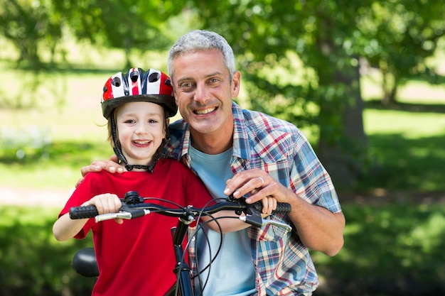 Heureux petit garçon sur son vélo avec son père