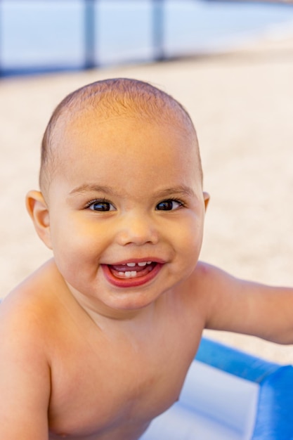 Heureux petit garçon souriant dans une piscine gonflable