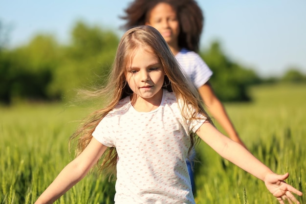 Heureux petites filles dans le champ vert