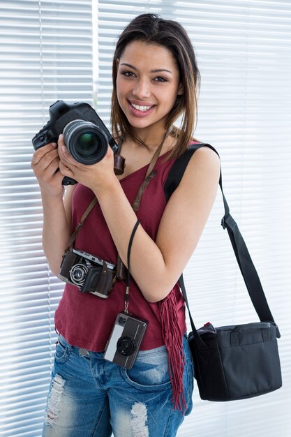 Heureux photographe féminin debout en studio