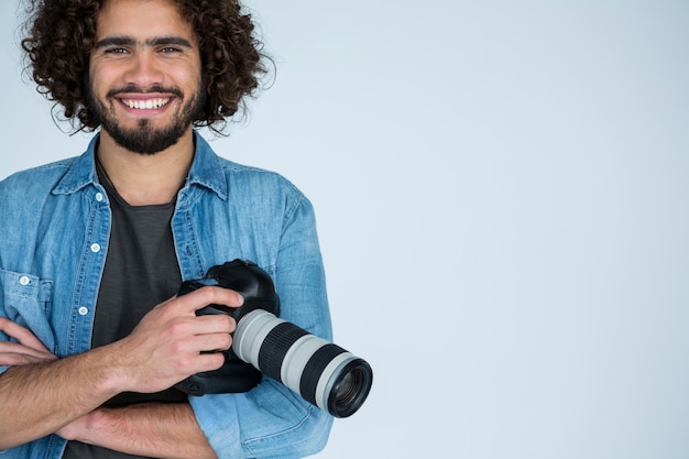 Heureux photographe masculin debout en studio