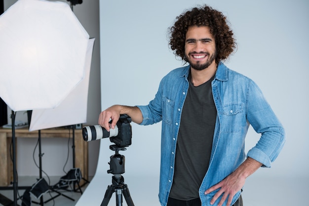 Heureux photographe masculin debout en studio