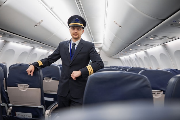 Heureux pilote caucasien confiant dans le salon de l'avion