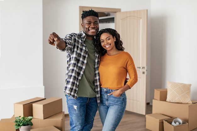 Heureux Époux Afro-Américains Tenant Une Nouvelle Clé De Maison Debout À L'intérieur