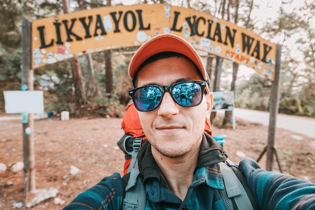 Heureux randonneur avec sac à dos de trekking prenant une photo de selfie au point de départ du sentier Lycian Way à Oludeniz Fethiye Voyage et aventure en Turquie