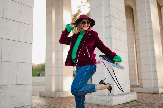 Heureux de s'amuser femme en tenue tendance de style automne marchant dans la rue