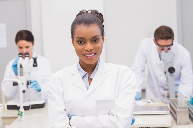 Heureux scientifique souriant à la caméra avec les bras croisés