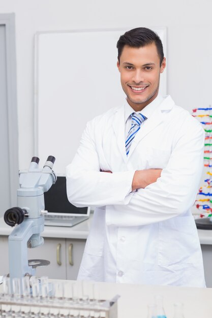 Heureux scientifique souriant à la caméra avec les bras croisés