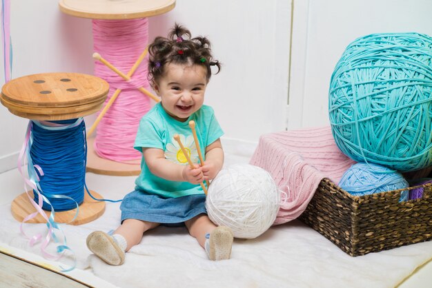 Heureux souriant douce petite fille assise sur le canapé, fille d&#39;anniversaire, un an