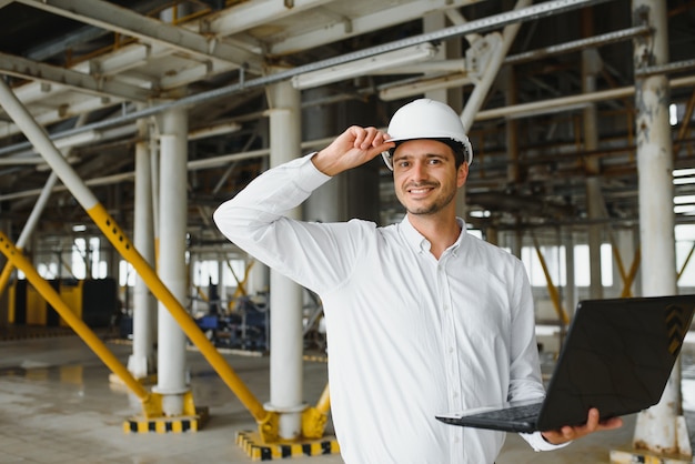 Heureux technicien industriel masculin à l'intérieur d'une usine