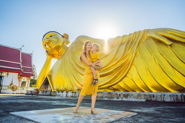 Heureux touristes mère et fils sur fond de statue de Bouddha couché
