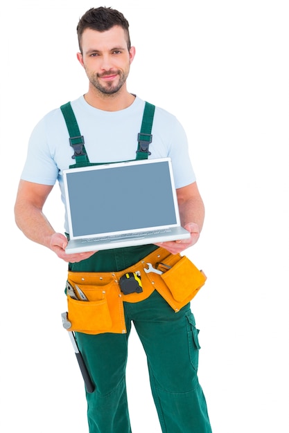 Heureux travailleur de construction tenant un ordinateur portable