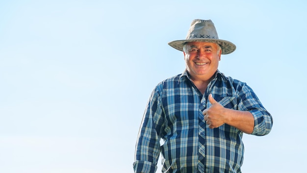 Heureux travailleur masculin mature regardant la caméra avec le geste du pouce vers le haut