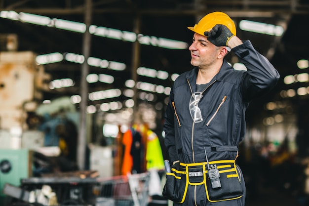 Heureux travailleur, portrait beau travail avec ceinture d'outils de combinaison de sécurité et homme de service radio en usine.