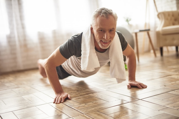 Heureux vieil athlète fait de la planche d'entraînement de soins de santé.