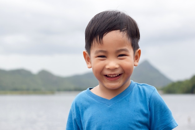 Heureux visage souriant garçon asiatique avec fond de montagne en plein air, copie image de l&#39;espace.