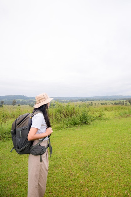 heureux voyageur hipster fille aux cheveux venteux souriant debout au sommet des montagnes ensoleillées