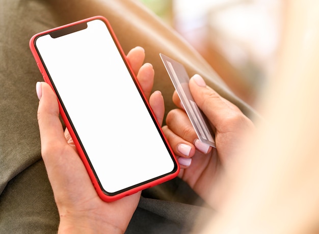 Photo high angle of woman holding smartphone et carte de crédit pour cyber lundi