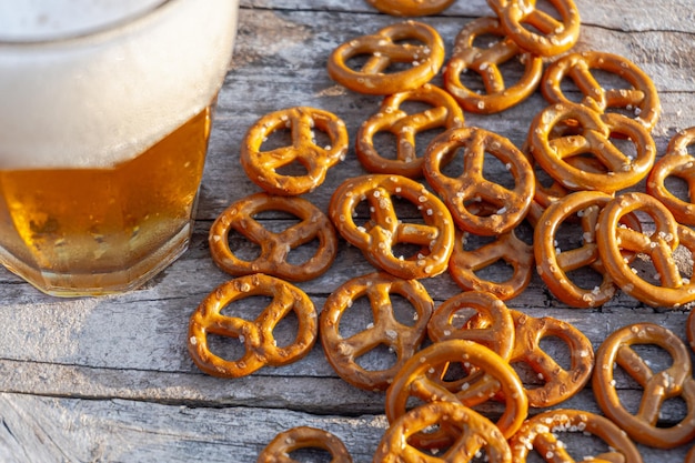 Highangle de bretzels salés et une tasse de bière sur une surface en bois