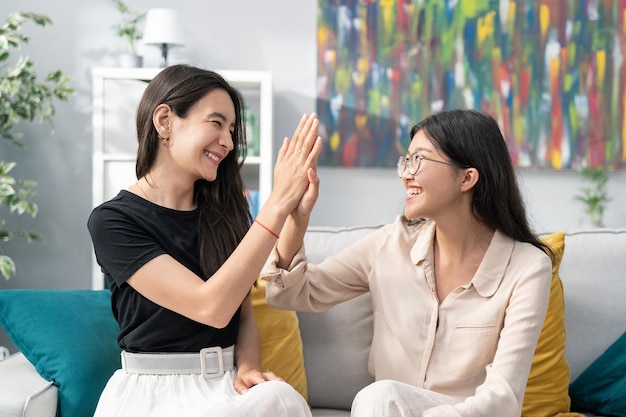 Highfiving avec les mains par deux filles beaux étudiants adolescents amis cheveux noirs beaut coréen asiatique