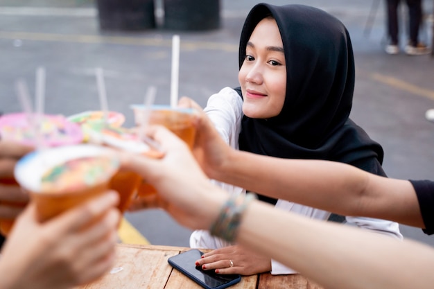 Hijab femme acclamant des boissons avec des amis