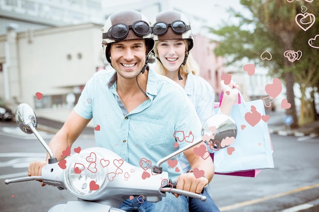 Hip Jeune Couple équitation Scooter Avec Des Sacs à Provisions Contre La Conception De Coeur De La Saint-valentin