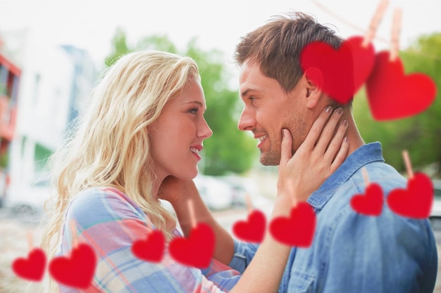 Hip jeune couple souriant l'un à l'autre contre des coeurs suspendus à une ligne