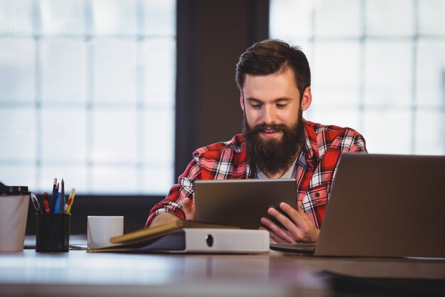 Hipster à l'aide de tablette numérique au bureau