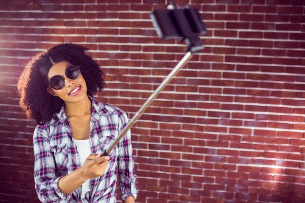 Hipster attrayant prenant des selfies avec selfiestick