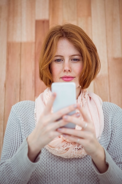 Hipster aux cheveux rouge à l'aide de smartphone