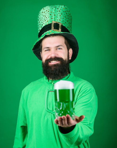 Hipster en chapeau de lutin vert tenant une chope de bière Homme irlandais avec barbe buvant de la bière verte Célébrant la saint patricks day au bar