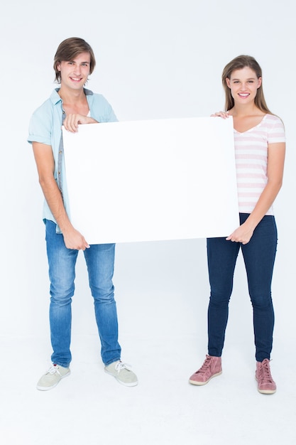 Hipster couple tenant une affiche et souriant à la caméra