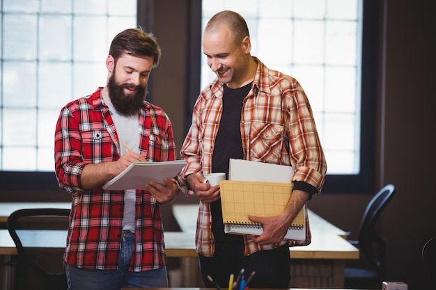 Hipster discutant sur ordinateur portable avec un collègue masculin