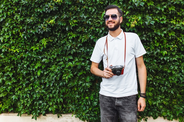 Hipster élégant avec une barbe et un appareil photo, se promener dans la ville avec un appareil photo