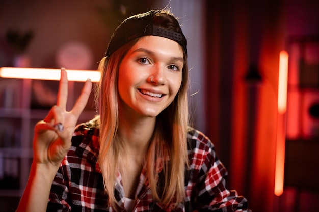 Photo hipster étudiant jeune fille caucasienne avec casquette noire et ordinateur portable pour la conversation vidéo