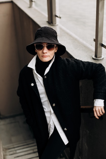 Hipster femme tendance chapeau noir manteau lunettes de soleil