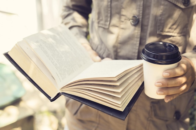 Hipster girl lit un livre et boit un café