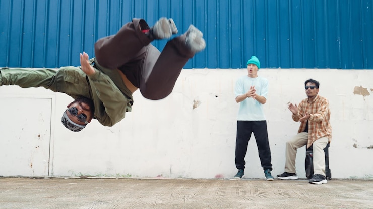 Photo un hipster habile faisant un saut à l'élastique sur le mur de la rue avec son ami endeavor.
