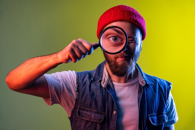 Hipster Homme Debout Tenant Une Loupe Regardant La Caméra Avec Une Expression Drôle D'oeil Grand Zoom