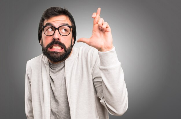 Hipster homme avec ses doigts croisés sur fond gris