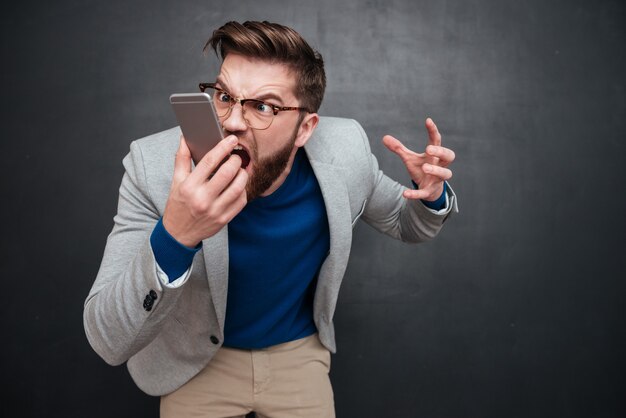 Hipster irrité avec téléphone en studio