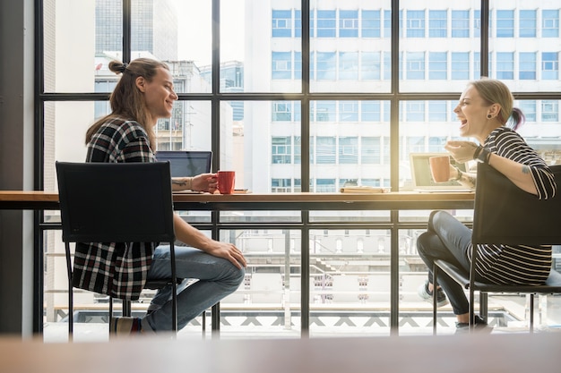 Hipster jeune couple freelancer parler avec bonheur et action de rire dans le lieu de travail café Loft.